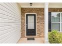 Close-up of the front door with brick accents and a welcoming entrance at 1576 Thornwick Trce, Stockbridge, GA 30281