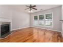 Open living room featuring hardwood floors, a fireplace, and large windows at 1576 Thornwick Trce, Stockbridge, GA 30281