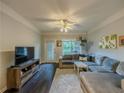 Comfortable living room with dark wood floors, crown molding, and a gray sectional at 2700 Pine Tree Ne Rd # 1013, Atlanta, GA 30324