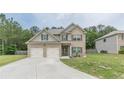Attractive exterior view of a two-story home with brick and siding, a well-maintained lawn, and a spacious driveway at 446 Vandenburg Dr, Villa Rica, GA 30180