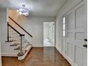 Bright entryway with hardwood floors, a staircase, and white doors creating a clean and inviting space at 5507 Martina Way, Dunwoody, GA 30338