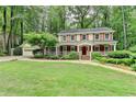 Charming two-story home featuring a welcoming front porch, red shutters, and a beautifully landscaped front yard at 5507 Martina Way, Dunwoody, GA 30338