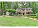 Charming two-story home features a covered front porch, red shutters, and a well-manicured lawn at 5507 Martina Way, Dunwoody, GA 30338