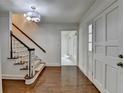 Bright foyer with hardwood floors, staircase, white trim, and view to a room at the end of the hall at 5507 Martina Way, Dunwoody, GA 30338