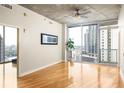 Bright living room featuring hardwood floors, large windows, and sliding glass door to balcony with city views at 44 Peachtree Ne Pl # 1824, Atlanta, GA 30309