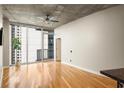 Bright living room featuring hardwood floors, large windows, and sliding glass door to balcony with city views at 44 Peachtree Ne Pl # 1824, Atlanta, GA 30309