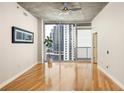 Bright living room featuring hardwood floors, large windows, and sliding glass door to balcony with city views at 44 Peachtree Ne Pl # 1824, Atlanta, GA 30309