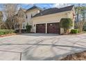 Attached two-car garage with an expansive driveway and manicured shrubbery at 612 Champions Dr, Mcdonough, GA 30253