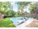 A refreshing backyard pool surrounded by lush trees with built in lounge chairs at 120 Vanira Se Ave, Atlanta, GA 30315