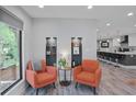 Cozy sitting area with two orange chairs, recessed lighting, and an open view to the kitchen at 120 Vanira Se Ave, Atlanta, GA 30315