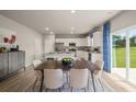 Open concept kitchen featuring stainless appliances, a large island, and a dining area with backyard access at 1208 Arnhem Dr, Hampton, GA 30228