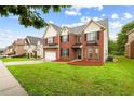 Charming red brick two-story home with lush green lawn and tidy landscaping at 1212 Ashton Park Dr, Lawrenceville, GA 30045