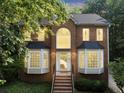 Inviting two-story brick home featuring a large front window and bay windows with elegant exterior lighting at 1625 Clark Lake Nw Dr, Acworth, GA 30102