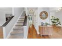 Hallway with staircase and light wood floors with a console table and mirror at 1625 Clark Lake Nw Dr, Acworth, GA 30102