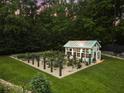 Picturesque greenhouse surrounded by garden beds and lush greenery at 390 Hembree Rd, Roswell, GA 30075