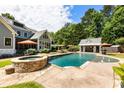 Backyard pool featuring an outdoor bar, tanning deck, hot tub and lounge chairs at 390 Hembree Rd, Roswell, GA 30075