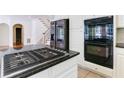 Kitchen island with black granite countertop and stainless steel gas cooktop at 5004 Duxford Se Dr, Smyrna, GA 30082