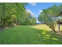 Expansive backyard with lush green grass, mature trees, and a storage shed at 1554 Owens Store Road Rd, Canton, GA 30115