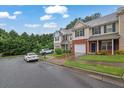 Exterior shot of townhomes with attached garages, lawns, and mature trees at 4055 Hill Station Ct, Sugar Hill, GA 30518