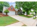 A well-maintained brick house featuring a spacious driveway and verdant front yard at 6360 Waveland Dr, Cumming, GA 30040