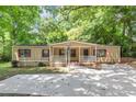 Charming single-story home with front porch, concrete drive, red shutters, and mature shade trees at 2017 S Deshon Rd, Lithonia, GA 30058