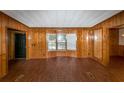 An empty living room featuring wood paneling, hard flooring, and natural light through a window at 2017 S Deshon Rd, Lithonia, GA 30058