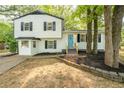 Inviting two-story home featuring white siding, black shutters, a bright blue front door, and landscaped garden beds at 4510 Virginia Nw Ave, Kennesaw, GA 30144