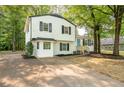 Inviting home with a manicured lawn, a concrete driveway, and a two-story white exterior with black shutters at 4510 Virginia Nw Ave, Kennesaw, GA 30144
