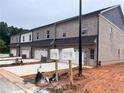 New construction townhome featuring garages, light brick, and mailbox at 3230 Cyrus Creek Dr, Kennesaw, GA 30152