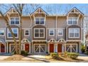Three-story townhome featuring a red door, garage, and updated curb appeal at 380 Grant Se Cir # 110, Atlanta, GA 30315
