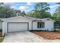A garage with a white door and concrete driveway is accompanied by a newly landscaped side yard at 1377 Hill Sw Dr, Conyers, GA 30094