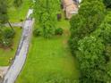 Expansive and well-maintained grassy lot surrounded by lush greenery and a paved street at 2095 Gherry Dr, Austell, GA 30106