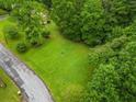 Lush green grassy lot surrounded by mature trees, adjacent to a paved road, offering a serene setting at 2095 Gherry Dr, Austell, GA 30106