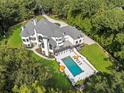 Aerial view of backyard oasis with inviting pool, lounge chairs, and a spacious manicured lawn at 330 Longvue Ct, Johns Creek, GA 30097