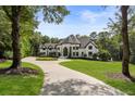 Beautiful home with circular driveway, lush landscaping, and mature trees at 330 Longvue Ct, Johns Creek, GA 30097