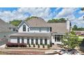 Back exterior view of home with patio and lush landscaping at 445 Sweet Ivy Ln, Lawrenceville, GA 30043