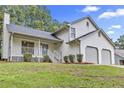 Inviting home exterior featuring a covered porch, two-car garage, and meticulously maintained landscaping at 6402 Grafton Ct, Austell, GA 30168