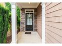 Inviting front entrance with stone accents, a stylish black door, and well-manicured greenery on a covered porch at 162 Ledgewood Mill Way, Lawrenceville, GA 30045