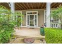 Close up of the welcoming front porch with detailed trim and manicured landscaping at 266 Monarch Village Way, Stockbridge, GA 30281