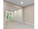 Neutral living room with carpet, light-colored walls, and a large window overlooking the backyard at 3614 Clearbrooke Way, Duluth, GA 30097