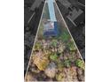 Aerial view of a house with solar panels in a large lot surrounded by mature trees in the fall at 382 Daffodil Dr, Temple, GA 30179