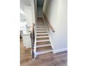Elegant staircase with wood treads, white risers, and a stylish handrail, leading to the upper level at 2407 Malster Ln, Lawrenceville, GA 30043