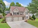 Aerial view of a lovely two-story home with a three-car garage and manicured lawn at 3260 Caney Creek Ln, Cumming, GA 30041