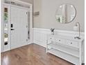 Inviting foyer showcasing a decorative mirror, console table, and gleaming hardwood floors at 3260 Caney Creek Ln, Cumming, GA 30041