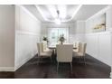 Elegant dining room with paneled walls, a modern light fixture, and seating for up to eight people at 3758 Lake Haven Way, Atlanta, GA 30349