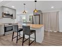 Stylish kitchen features a butcher block island, gray cabinets, stainless steel appliances, and modern pendant lights at 597 Rich Davis Rd, Hiram, GA 30141