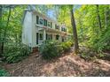 Beautiful two-story home with a front porch nestled among lush trees and landscaping at 6360 Lakeview Ter, Douglasville, GA 30135