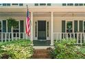 Inviting front porch view features a swing, American flag, and lush landscaping at 6360 Lakeview Ter, Douglasville, GA 30135