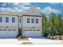 Charming townhome with white siding, stone accents, and attached two-car garage at 2413 Malster Ln, Lawrenceville, GA 30043