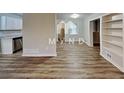 Open living space with an adjacent kitchen, wood-look flooring, and neutral paint at 7054 Chappell Cir, Atlanta, GA 30360